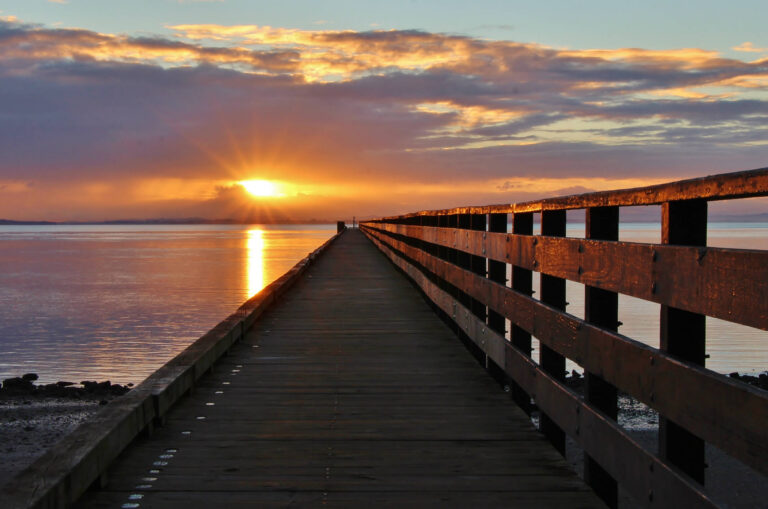 iStock 2163717875 long pier with sunrise 768x509